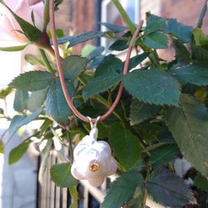 Flower Freshwater Pearl with a golden topaz set in middle of pearl. Sterling silver split bail on natural leather cord.